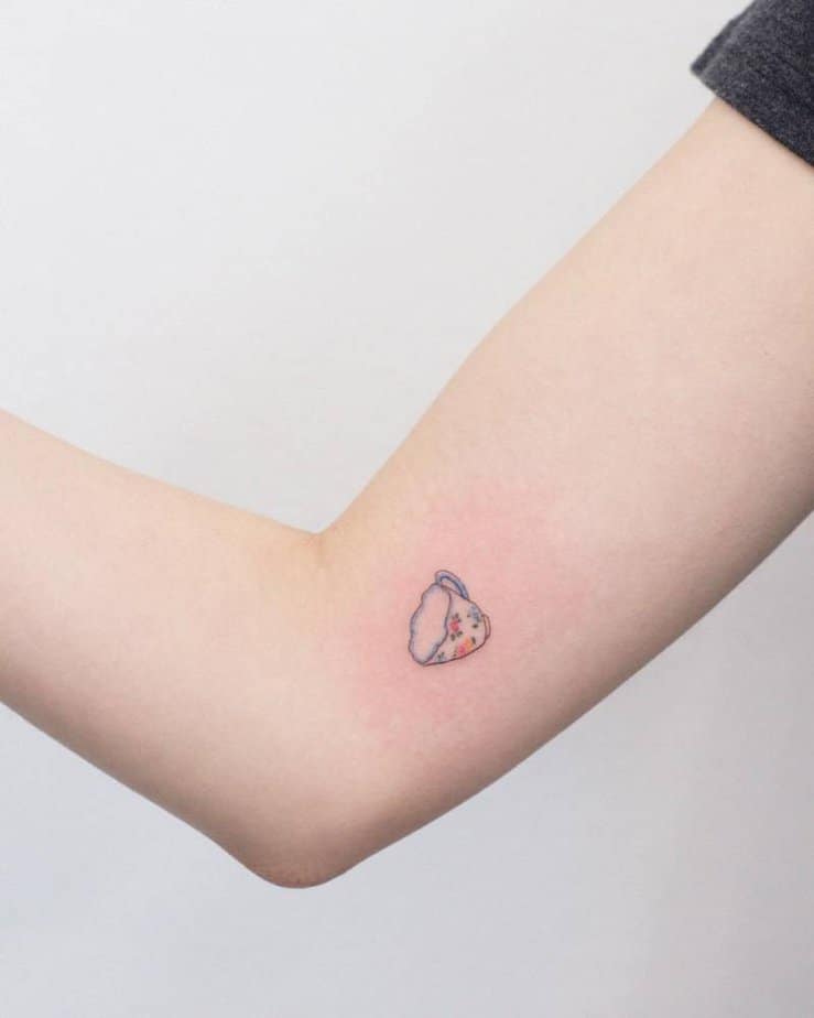 Tiny floral teacup on the inside of the arm