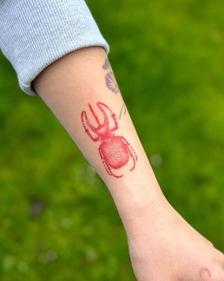 Bold beetle rendered entirely in red ink with detailed linework