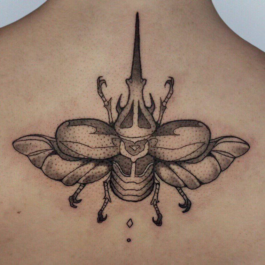 Large back piece of a beetle with outstretched wings and detailed linework