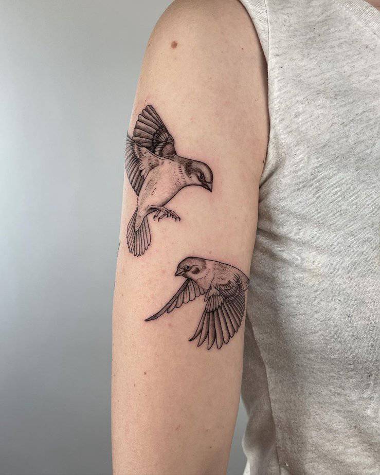 1. A tattoo of two house sparrows on the upper arm