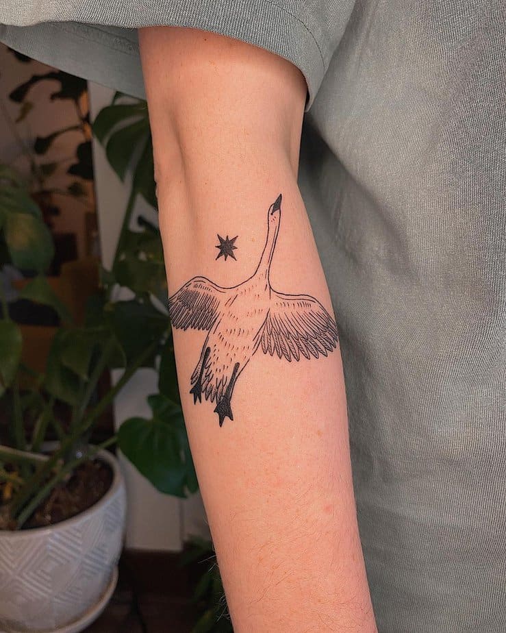 Flying swan tattoo with a star