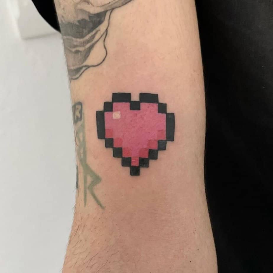 Pink Minecraft heart tattoo on arm