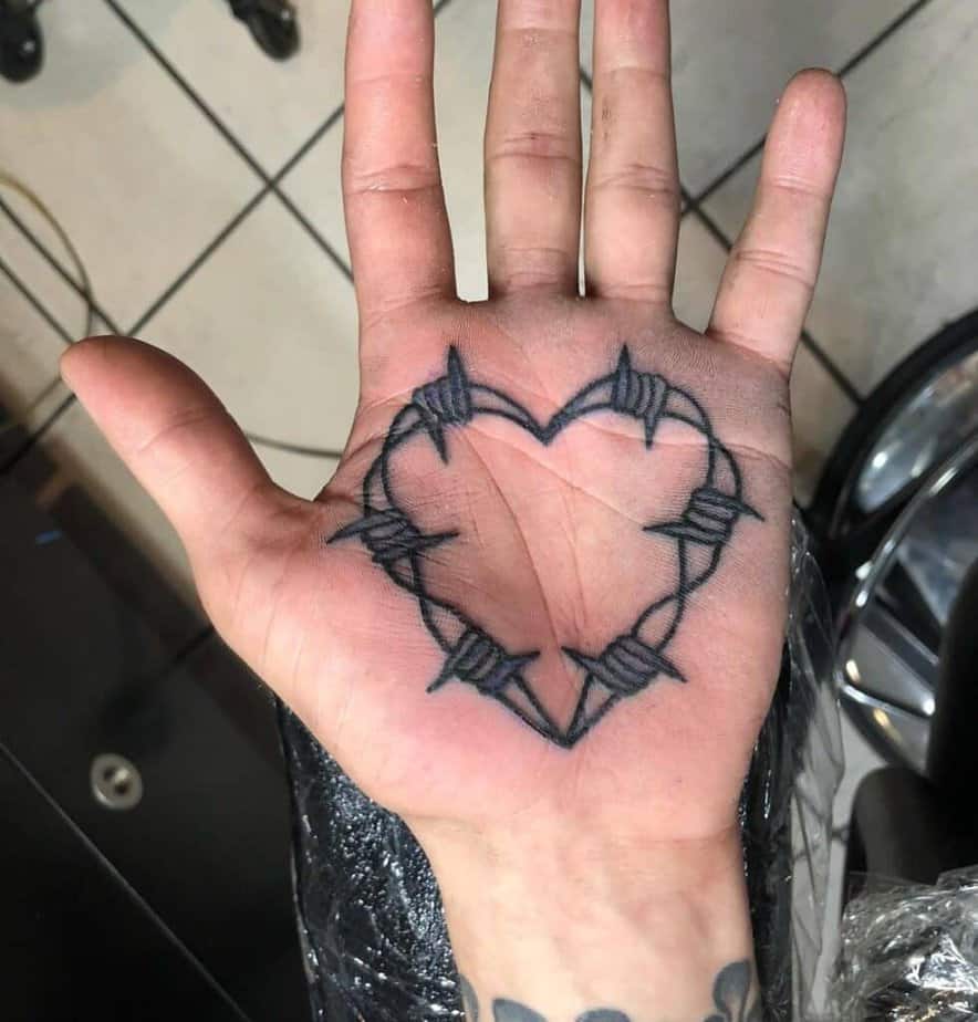 Barbed wire heart palm tattoo
