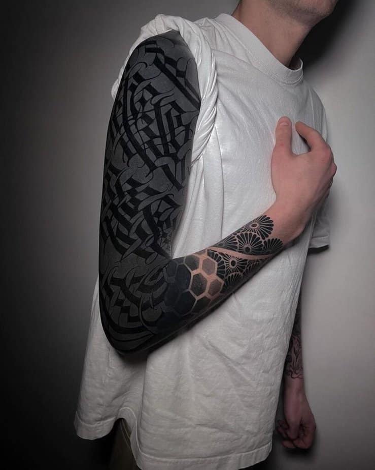 2. A black sleeve tattoo with black symbols
