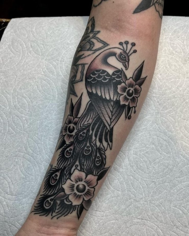 17. A forearm peacock tattoo