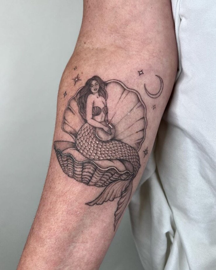 2. A tattoo of a mermaid sitting on a seashell 