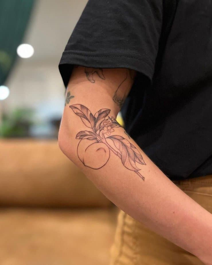 19. A peach branch tattoo on the forearm 