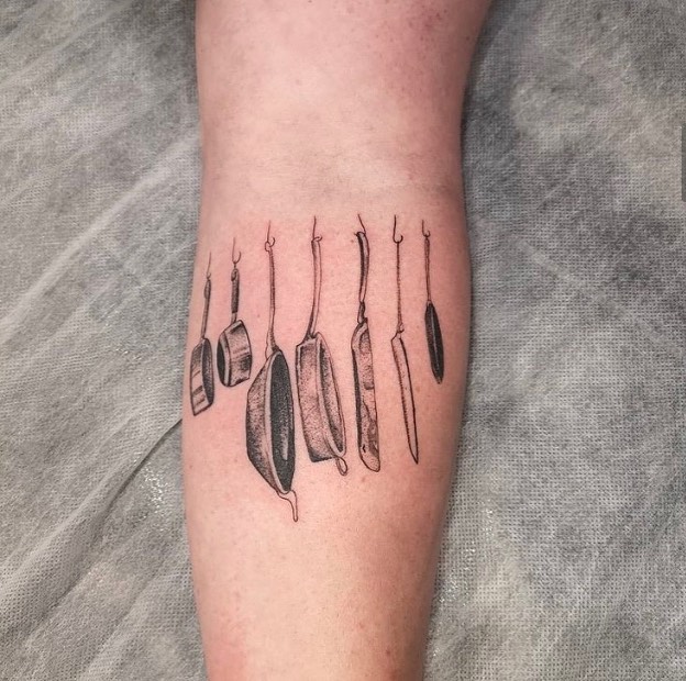 13. A tattoo of pots and pans on the inside of the arm