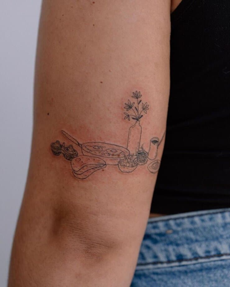 18. A tattoo of a beautiful breakfast spread on the back of the arm