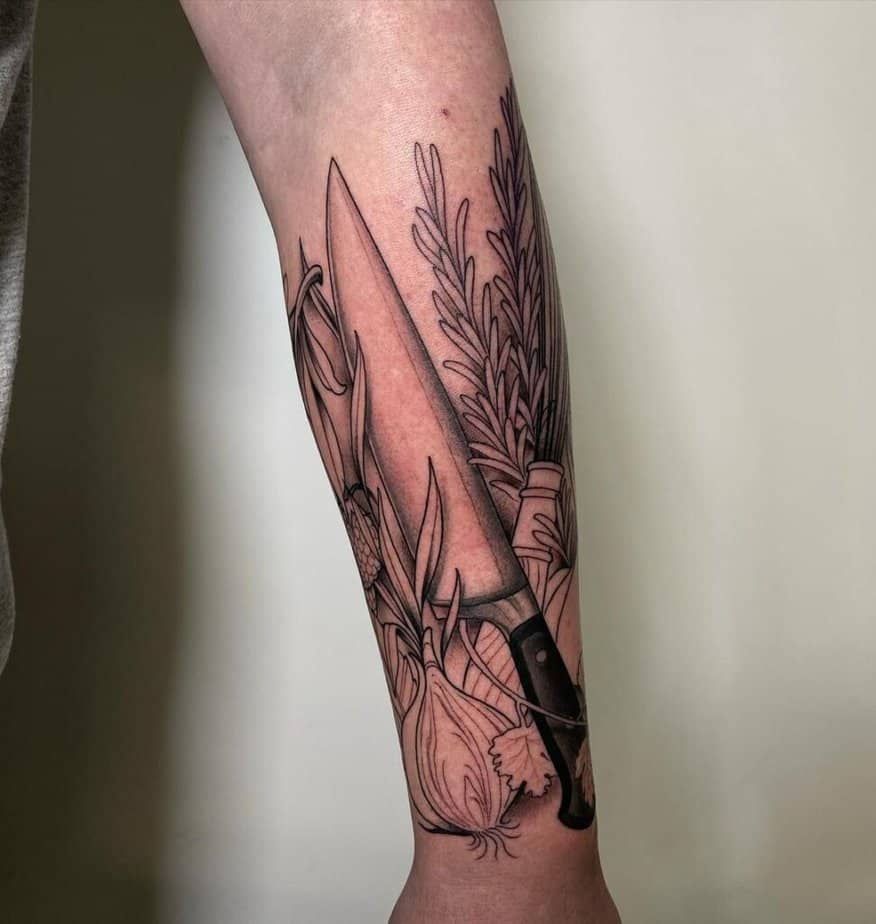 21. A tattoo of a knife, veggies, and herbs on the forearm
