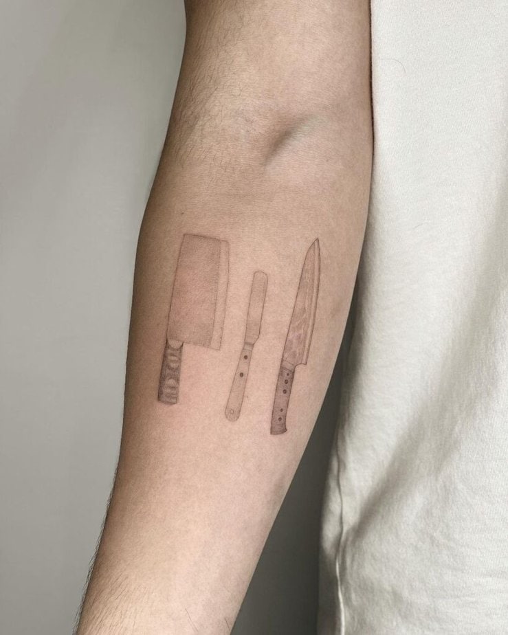 9. A tattoo of kitchen knives on the forearm