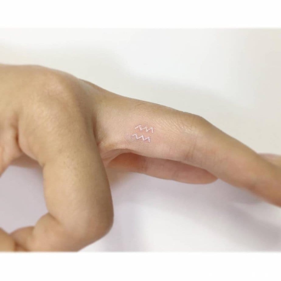 Tiny white ink Aquarius symbol for a subtle statement