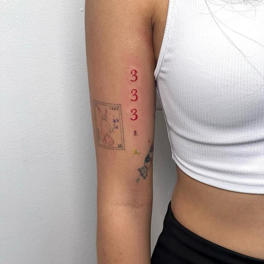 Red lettering 333 tattoo