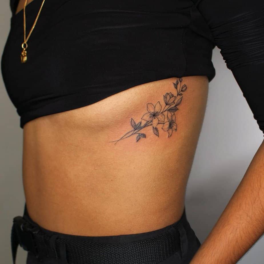 11. A black jasmine tattoo on the ribcage