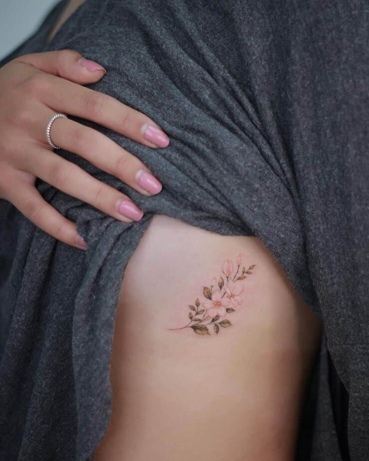3. A colorful jasmine tattoo on the ribcage