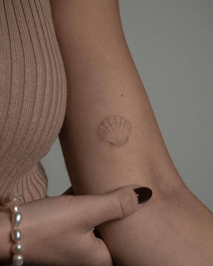 16. A soft and subtle shell tattoo