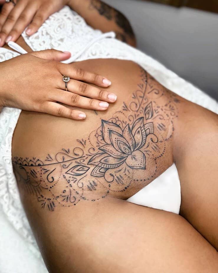 19. A tummy tuck tattoo with a lotus flower and ornaments