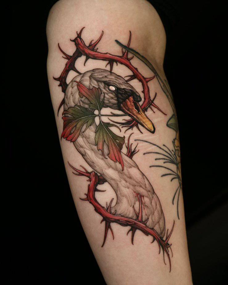 An injured swan tattoo with colorful thorns