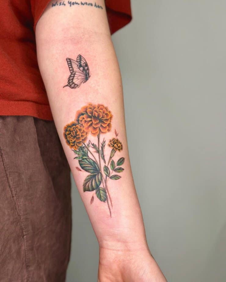 Butterfly and marigold forearm tattoo