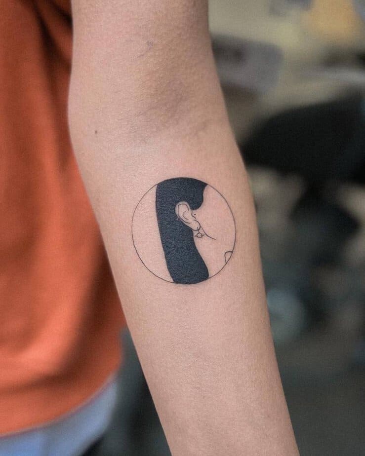 Girl with a planet earing circle tattoo