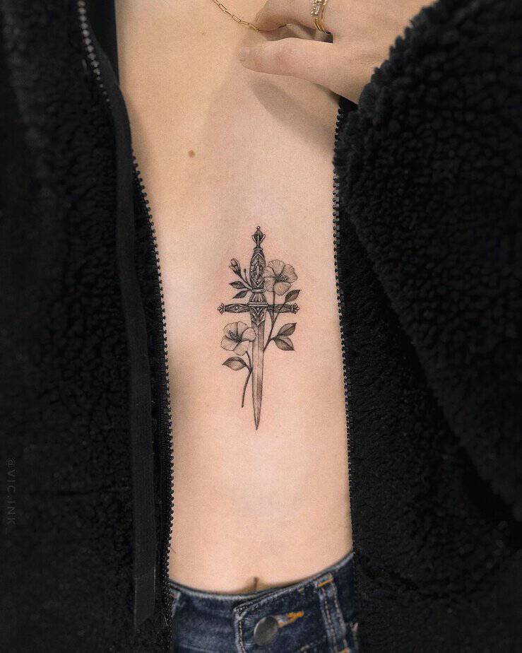 Hibiscus and dagger sternum tattoo