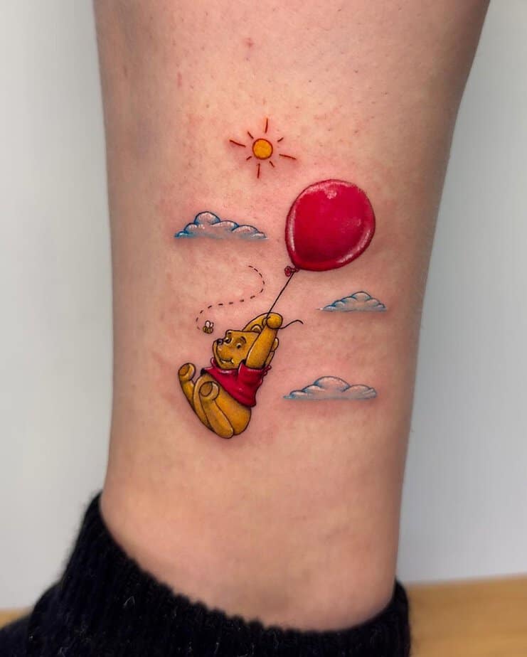 Winnie holding a red balloon ankle tattoo