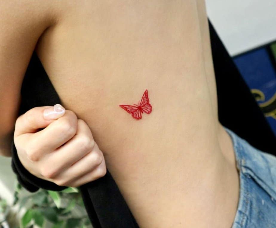 20. A red butterfly tattoo on the ribcage