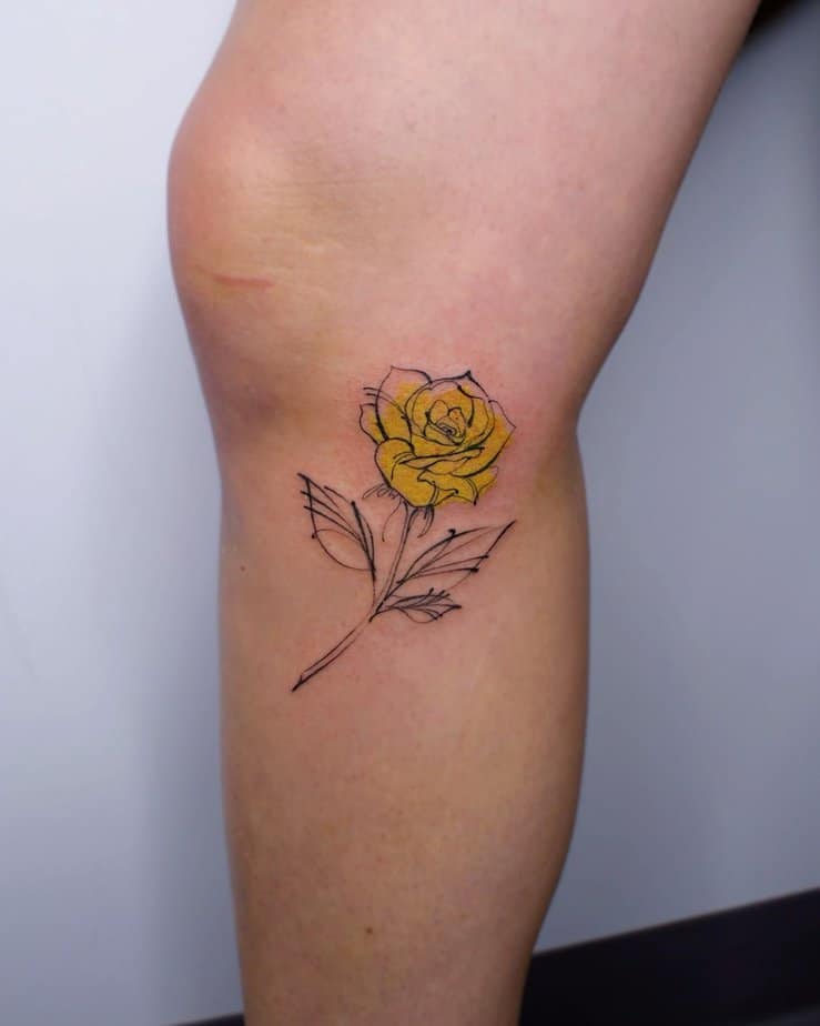Yellow rose tattoo on the leg