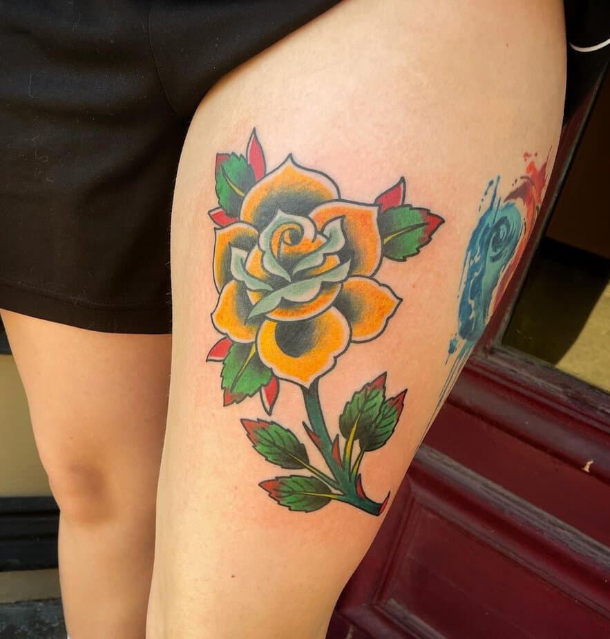 Yellow rose tattoo on the thigh